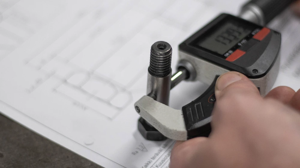 A Mikromet worker holding a device used for calculating the size of a piece